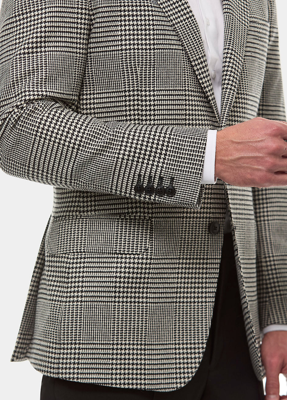 Saco Ready To Wear Tejido Negro Gales
92% Lana Virgen, 7% Cashmere, 1% Elastano – Entrega Inmediata

El Saco Ready To Wear Tejido Negro Gales de HAVOC es la elección definitiva para el hombre que busca un equilibrio entre lujo y estilo contemporáneo. Confeccionado con una mezcla exquisita de 92% lana virgen y 7% cashmere, este saco ofrece una suavidad y calidez excepcionales, mientras que el 1% de elastano aporta un ajuste perfecto que se adapta a tu figura de manera natural. El tejido de Gales en un elegan
